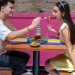 A happy couple sharing food at a vibrant restaurant in Mexico City, enjoying a romantic moment.