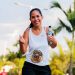 Smiling woman running a marathon outdoors in warm weather.